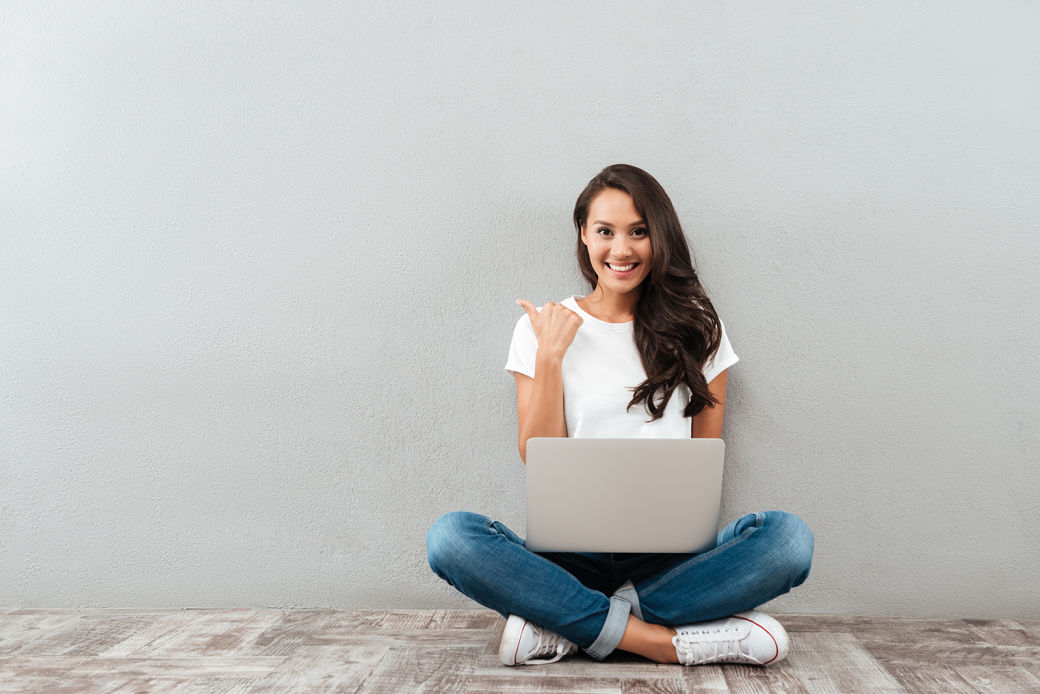 Happy smiling asian woman working on laptop
